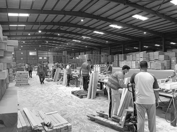 Workers assembling timber pallets at benches inside the group's pallet workshop